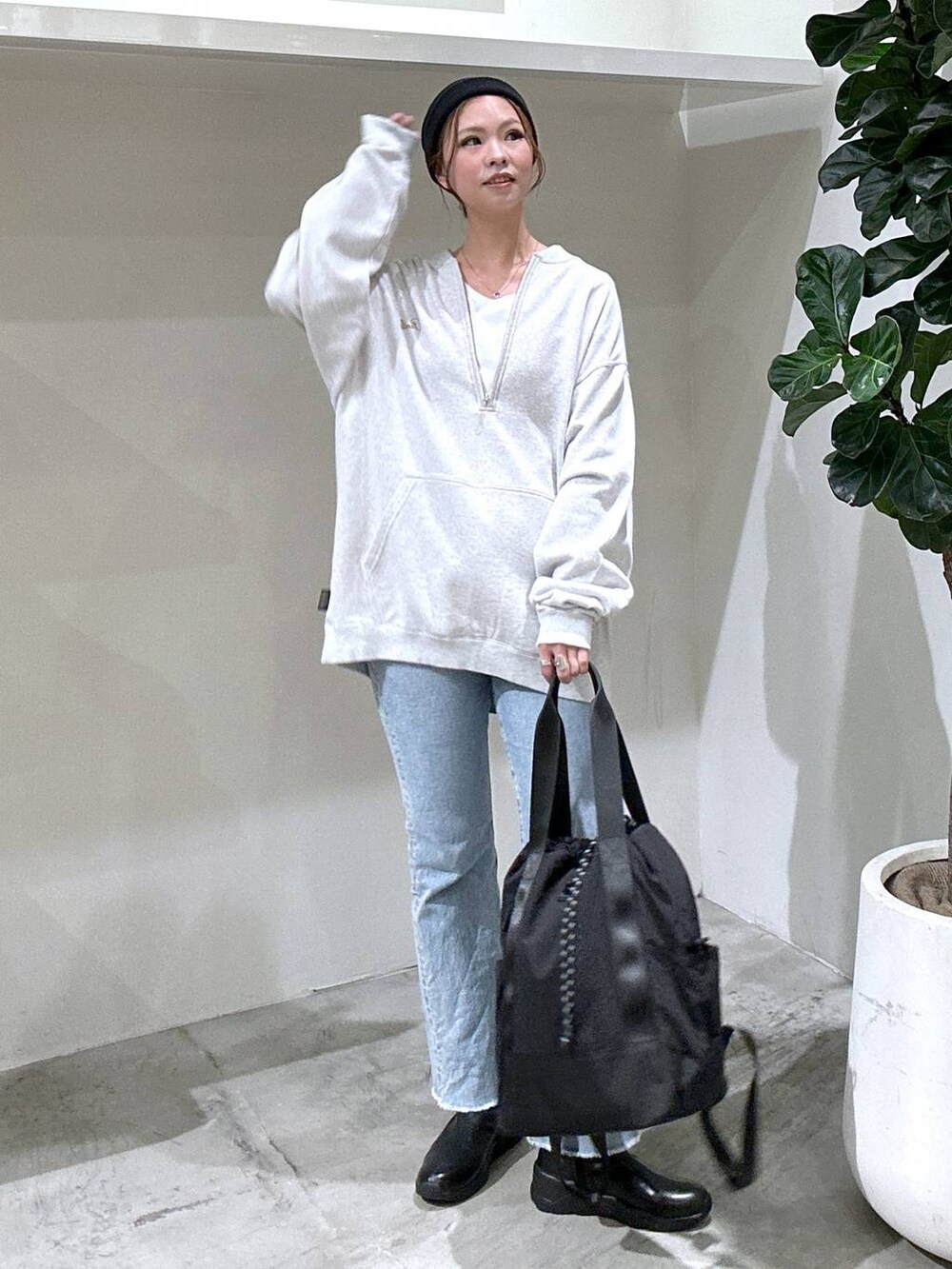 ブルー系のデニムパンツ、ブラック系のバックパック/リュック、グレー系のスウェットを着用したレディースの秋コーディネートの2枚目の写真