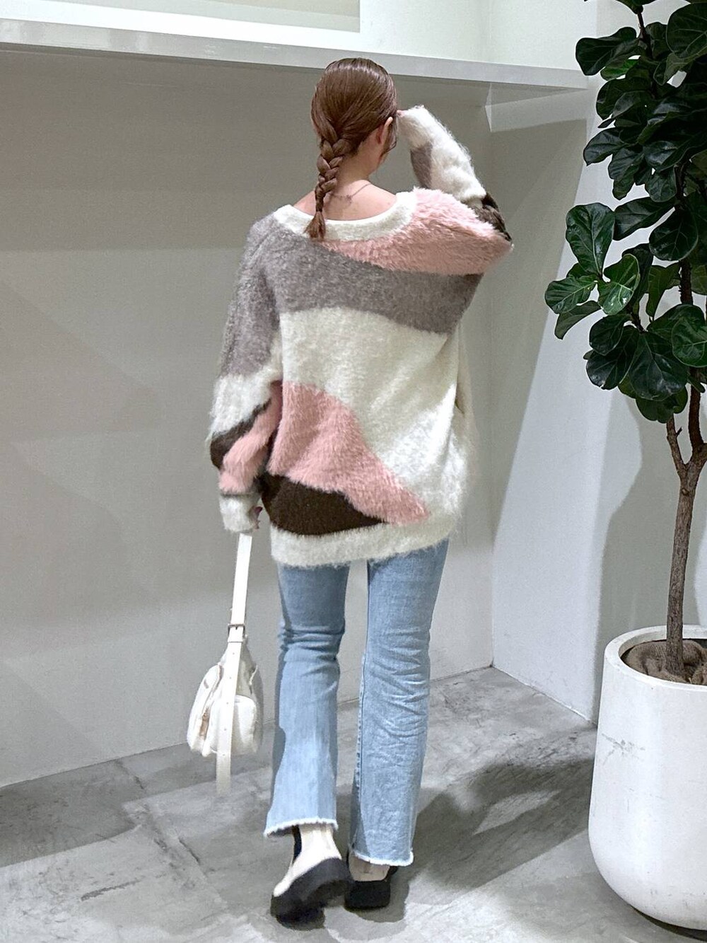 ブルー系のデニムパンツ、ホワイト系のブーツ、ホワイト系のカーディガン/ボレロを着用したレディースの秋コーディネートの3枚目の写真