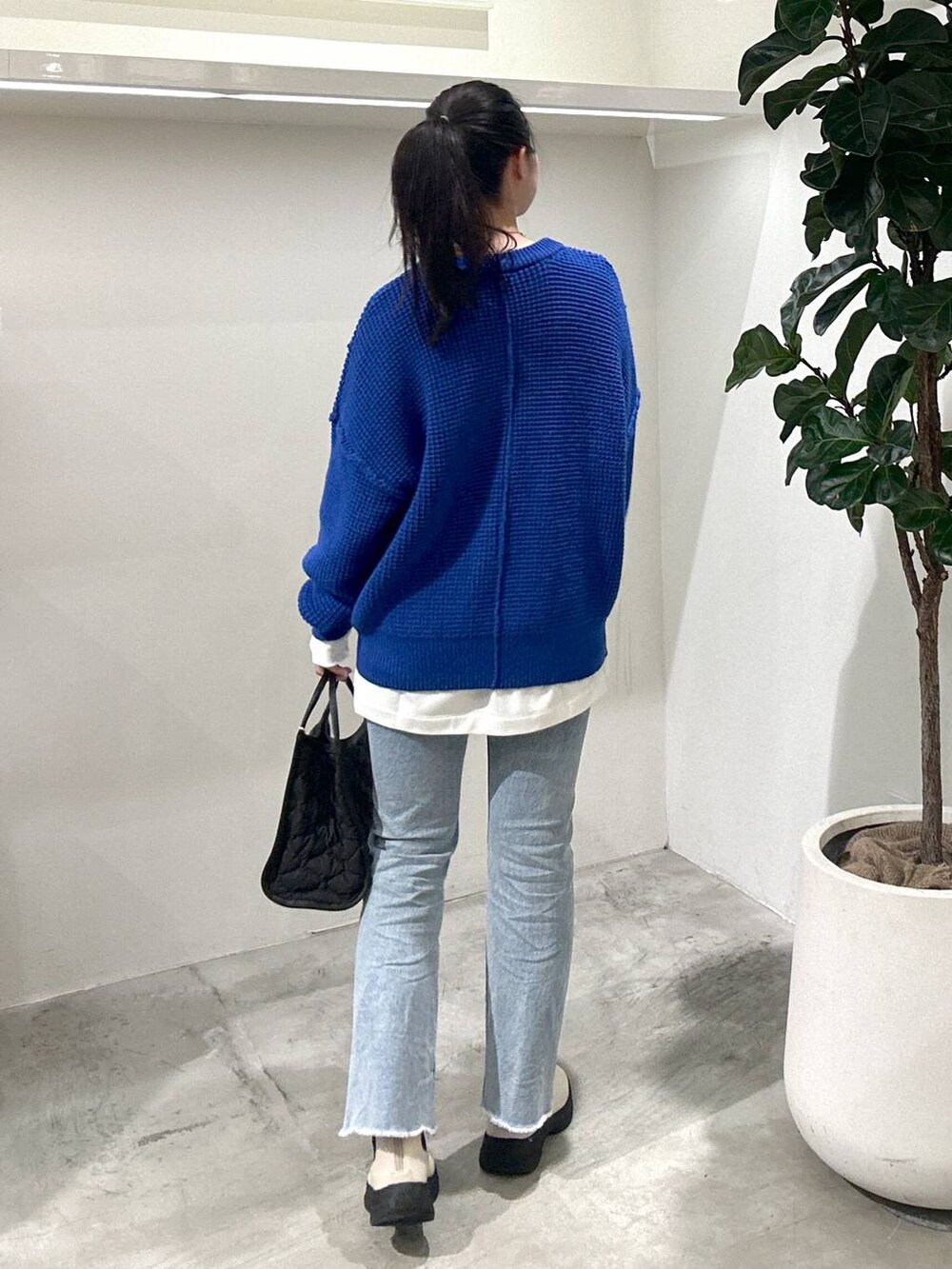 ブルー系のデニムパンツ、ホワイト系のTシャツ/カットソー、ブラック系のハンドバッグを着用したレディースの冬コーディネートの3枚目の写真