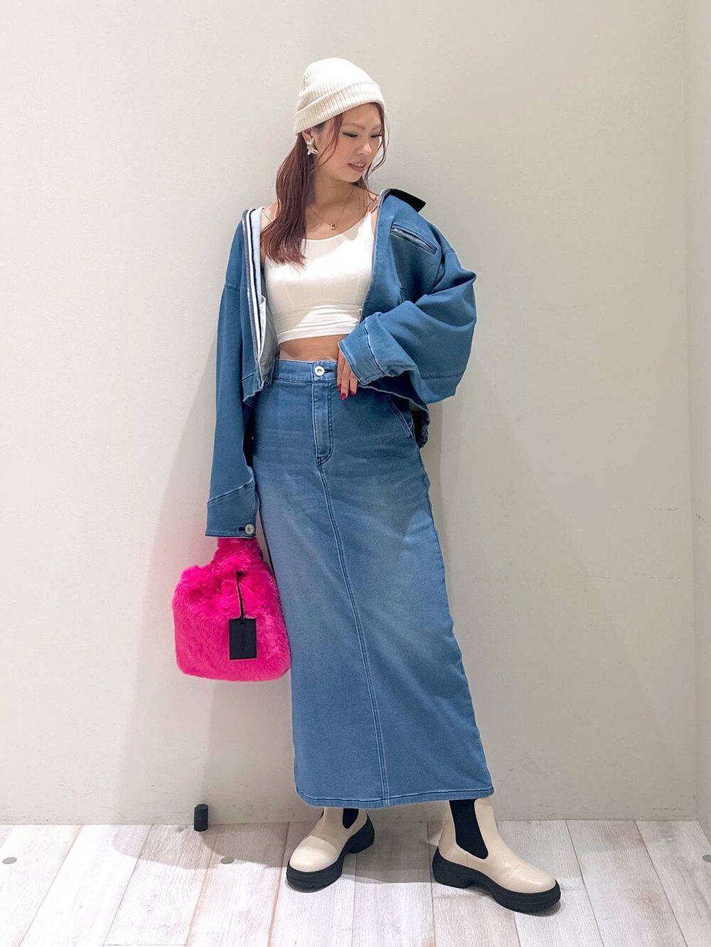 ブルー系のデニムスカート、ブルー系のブルゾン、ピンク系のハンドバッグを着用したレディースの秋コーディネートの2枚目の写真