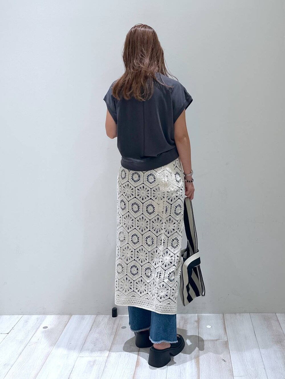 ブラック系のサンダル、ホワイト系のスカート、ホワイト系のエコバッグ/サブバッグを着用したレディースの秋コーディネートの4枚目の写真