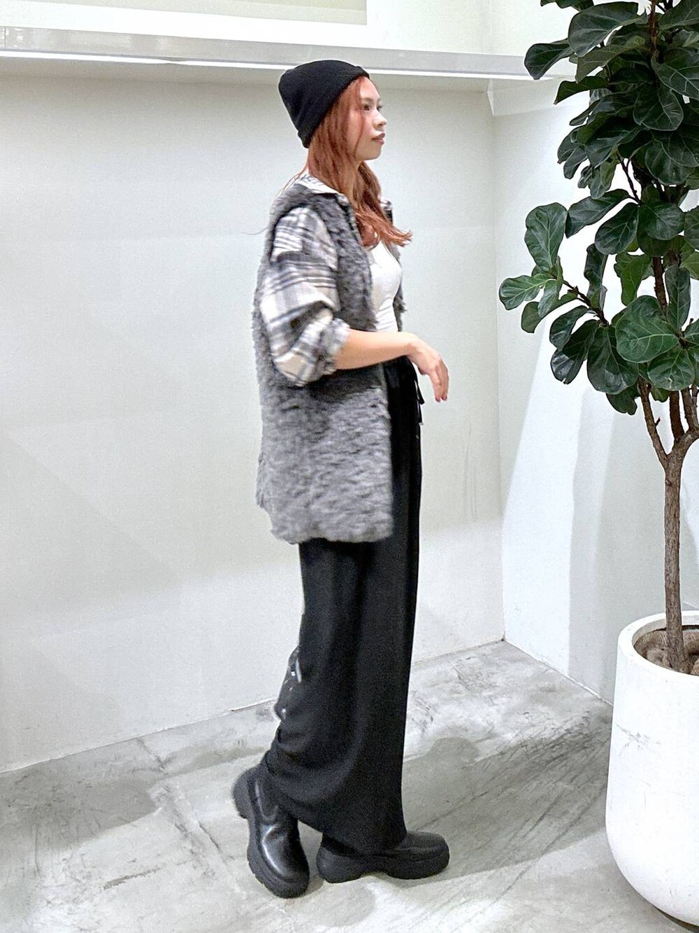 グレー系のベスト、ブラック系のその他パンツ、ブラック系のショルダーバッグを着用したレディースの秋コーディネートの2枚目の写真