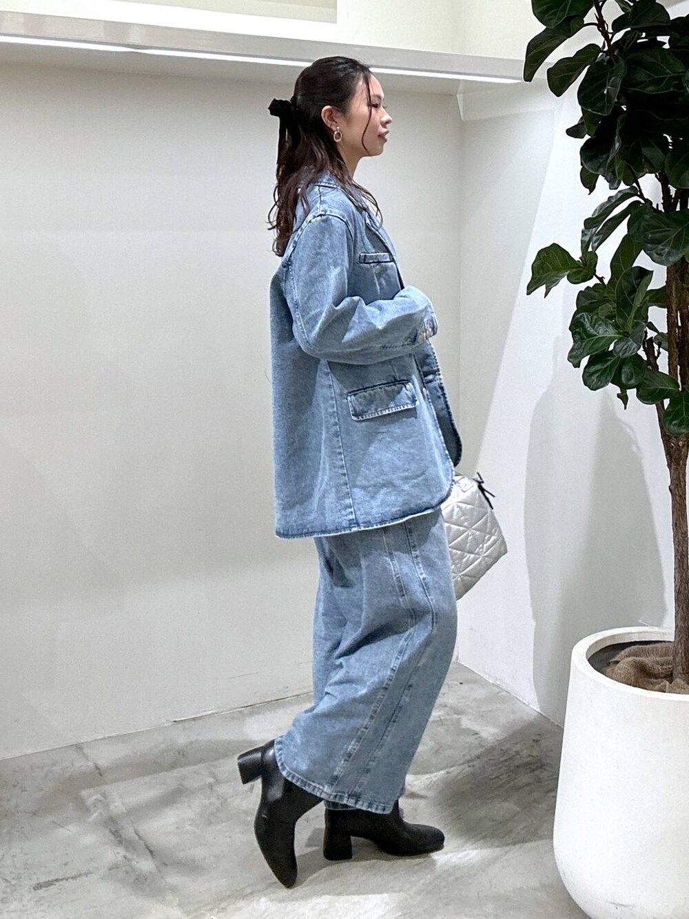 ブラック系のブーツ、ブルー系のデニムパンツ、ブルー系のその他アウターを着用したレディースの冬コーディネートの3枚目の写真