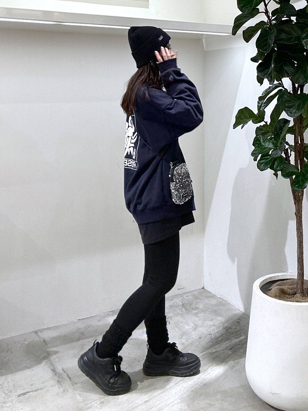 グレー系のショルダーバッグ、ブラック系のスニーカー、ブルー系のスウェットを着用したレディースの冬コーディネートの3枚目の写真