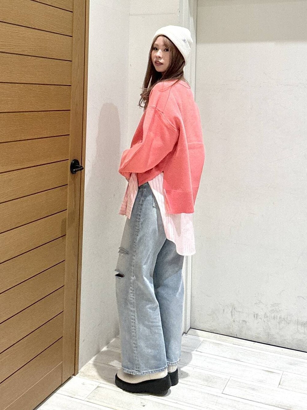 ベージュ系のブーツ、ブルー系のデニムパンツ、ホワイト系のハンドバッグを着用したレディースの春コーディネートの3枚目の写真