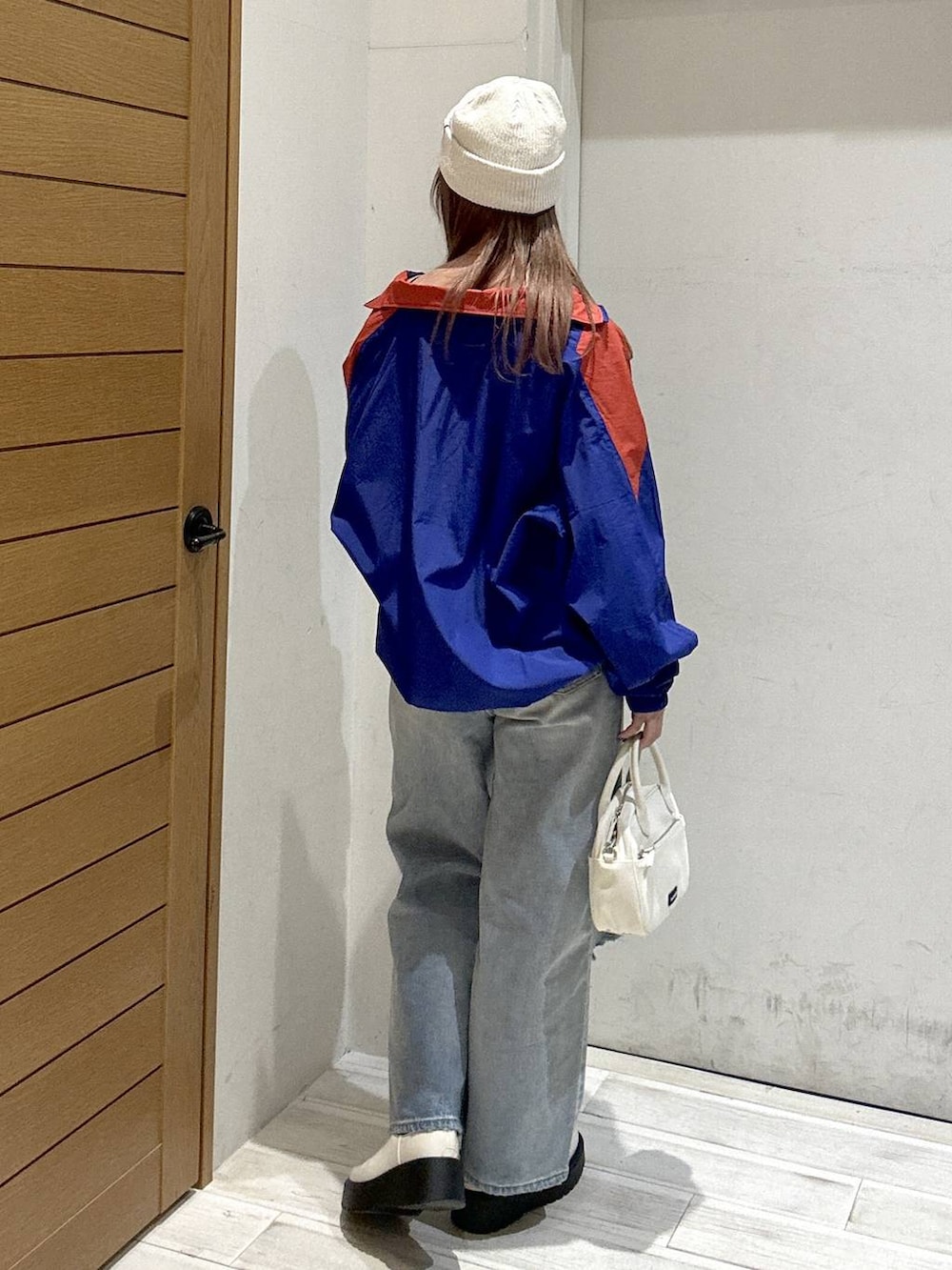 ブラック系のキャミソール、ベージュ系のブーツ、ブルー系のデニムパンツを着用したレディースの春コーディネートの3枚目の写真