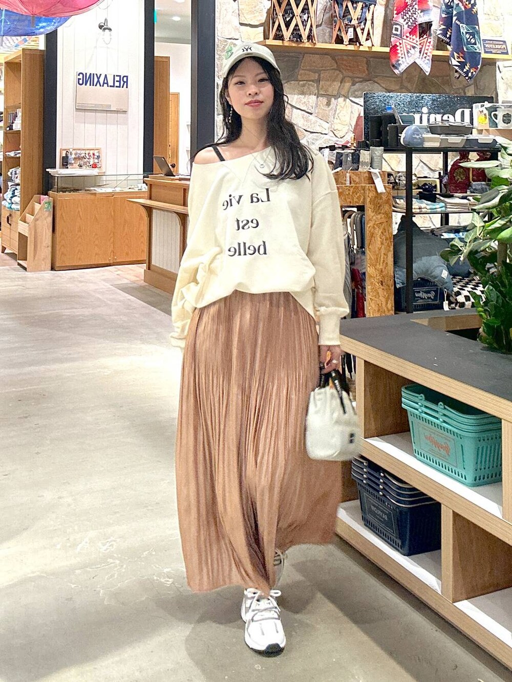 ホワイト系のスウェット、ベージュ系のショルダーバッグ、ブラック系のキャミソールを着用したレディースの冬コーディネートの2枚目の写真