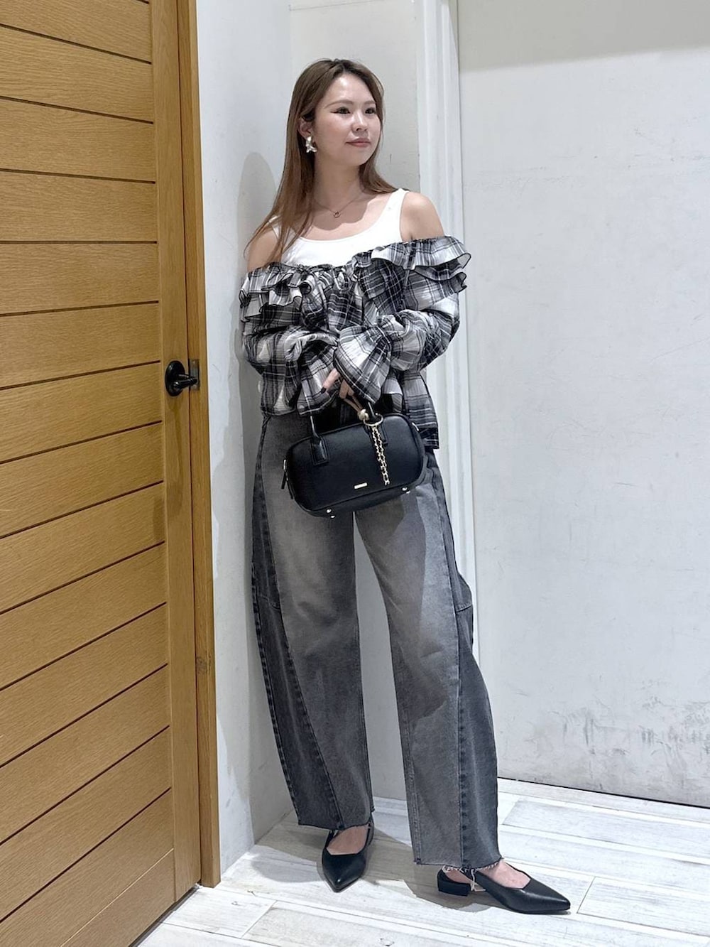 ブラック系のパンプス、ブラック系のデニムパンツ、ブラック系のハンドバッグを着用したレディースの春コーディネートの4枚目の写真