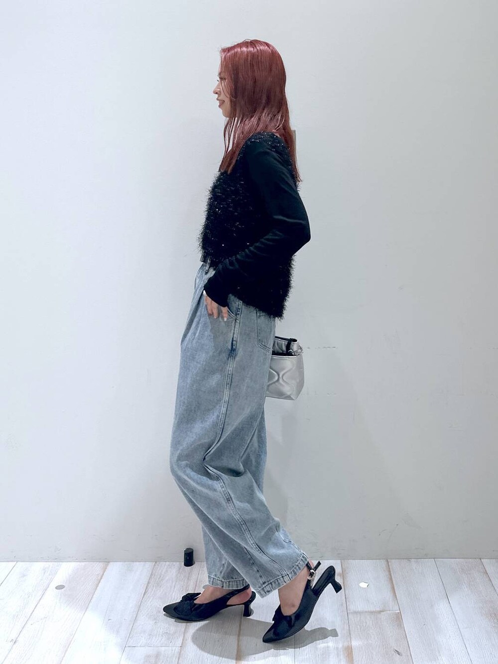 ブラック系のショルダーバッグ、ブラック系のベスト、ブラック系のパンプスを着用したレディースの秋コーディネートの2枚目の写真