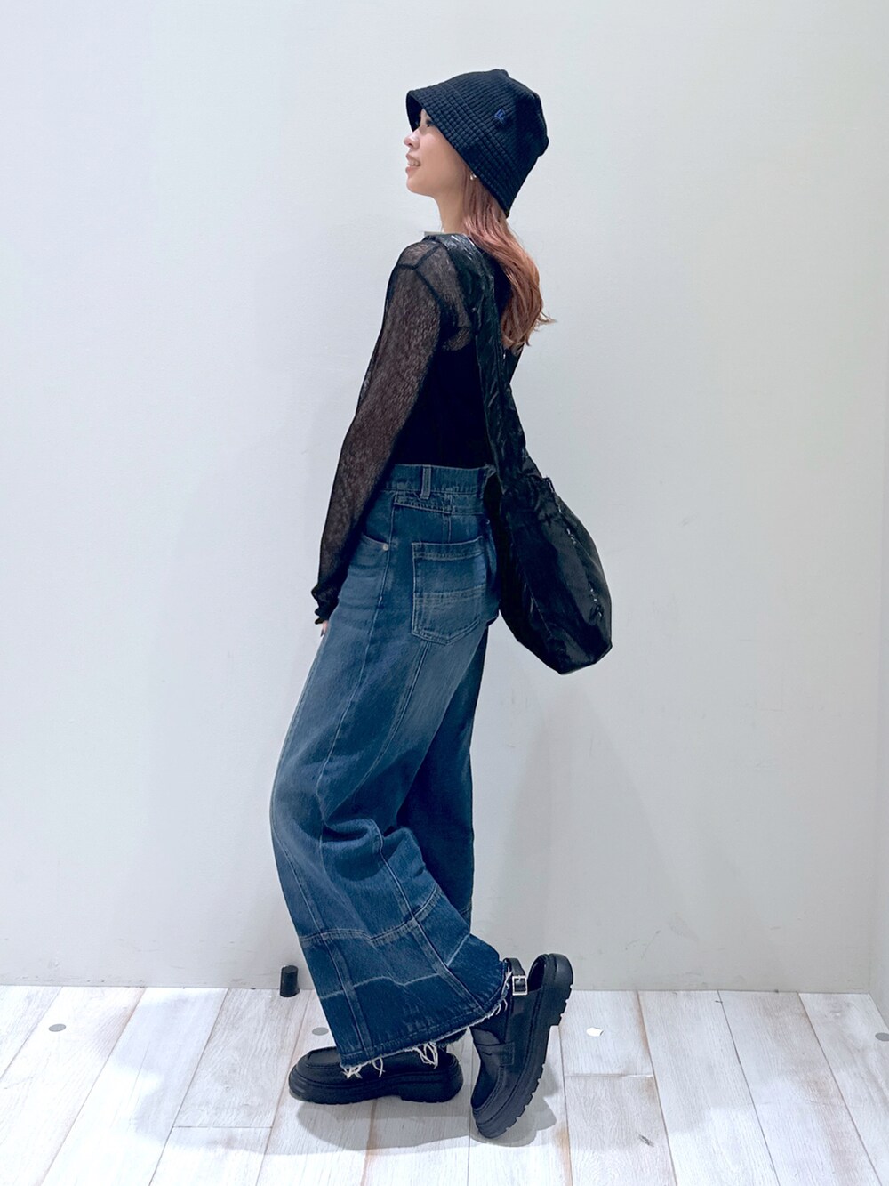 ブルー系のデニムパンツ、ブラック系のローファー、ブラック系のショルダーバッグを着用したレディースの春コーディネートの4枚目の写真