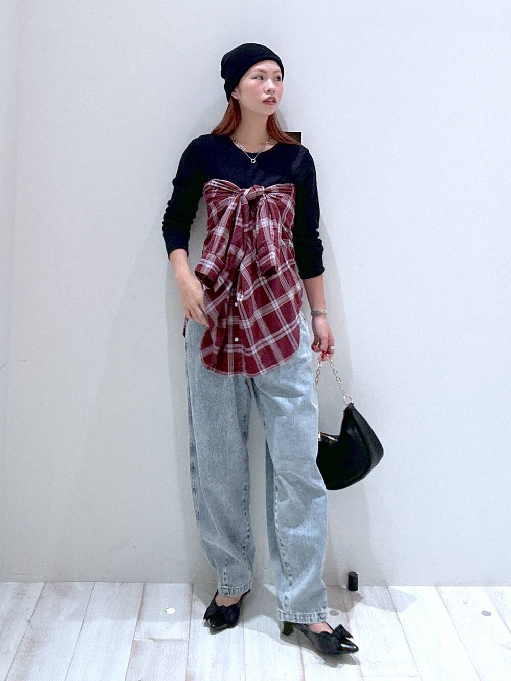 レッド系のシャツ/ブラウス、ブラック系のパンプス、ブルー系のデニムパンツを着用したレディースの秋コーディネートの2枚目の写真