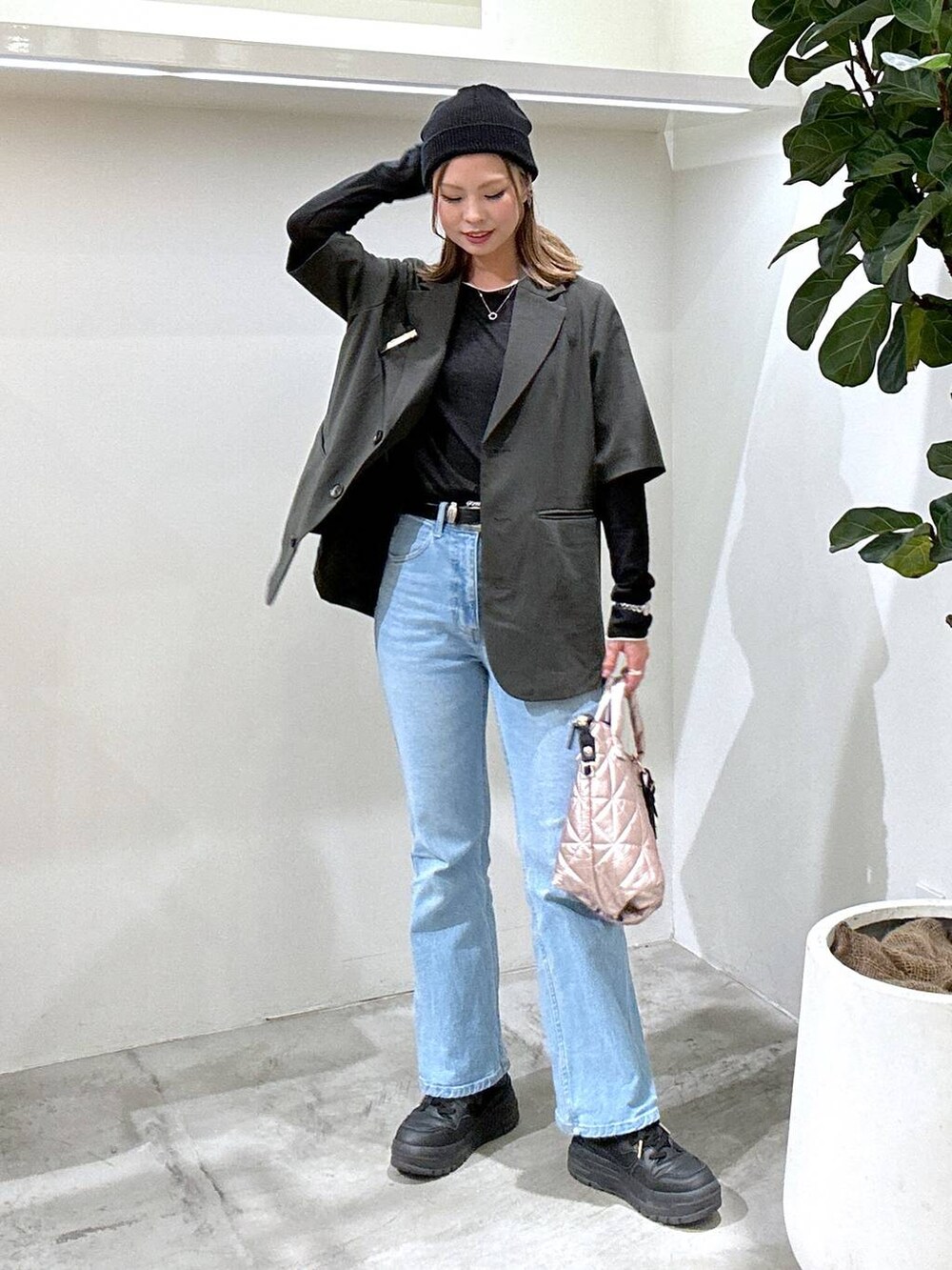 ブラック系のスニーカー、ブラック系のTシャツ/カットソー、ブルー系のデニムパンツを着用したレディースの春コーディネートの2枚目の写真