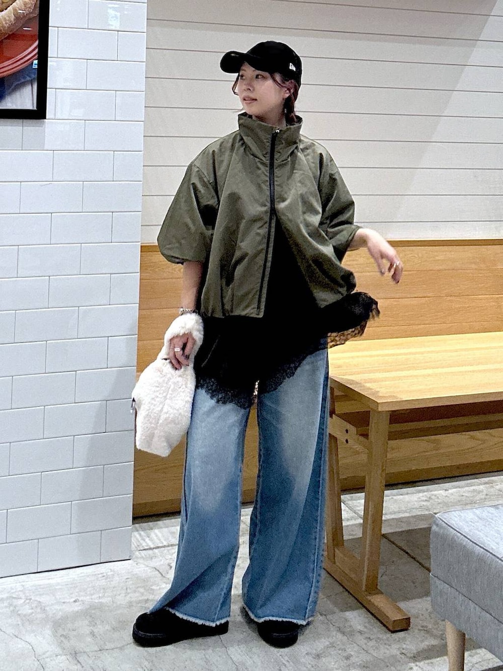 ブラック系のその他シューズ、ブラック系のデニムパンツ、ベージュ系のハンドバッグを着用したレディースの秋コーディネートの2枚目の写真