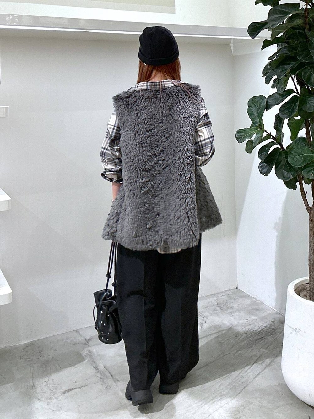 グレー系のベスト、ブラック系のその他パンツ、ブラック系のショルダーバッグを着用したレディースの秋コーディネートの3枚目の写真