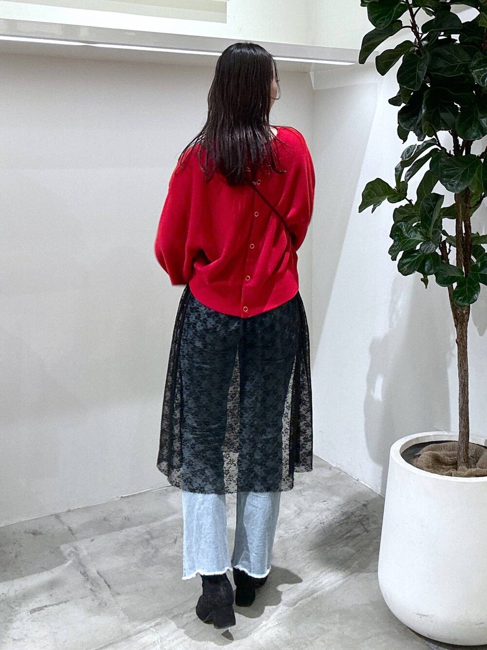 ブラック系のショルダーバッグ、ブルー系のデニムパンツ、ブラック系のスカートを着用したレディースの冬コーディネートの3枚目の写真