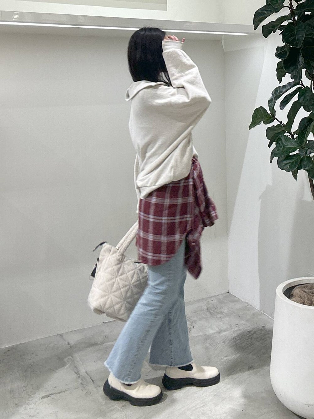 レッド系のシャツ/ブラウス、ブルー系のデニムパンツ、ホワイト系のブーツを着用したレディースの冬コーディネートの3枚目の写真