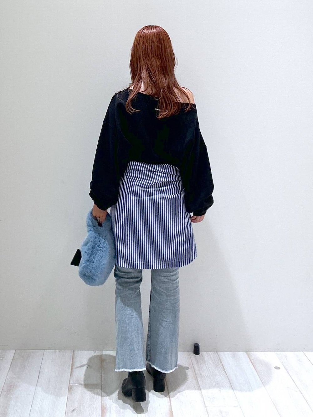 ブルー系のデニムパンツ、ブラック系のスウェット、ブルー系のシャツ/ブラウスを着用したレディースの秋コーディネートの4枚目の写真