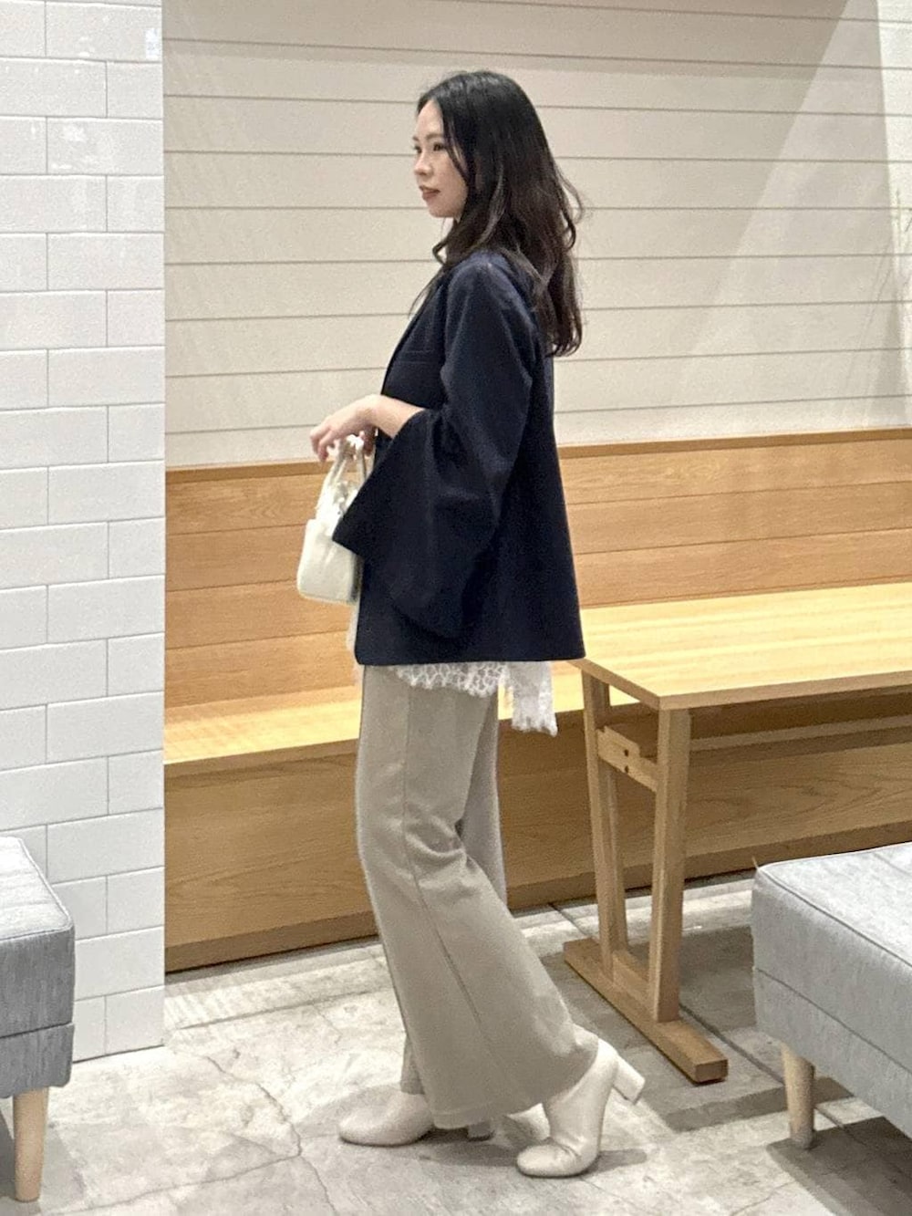 ブルー系のテーラードジャケット、ベージュ系のその他パンツ、ホワイト系のハンドバッグを着用したレディースの春コーディネートの2枚目の写真