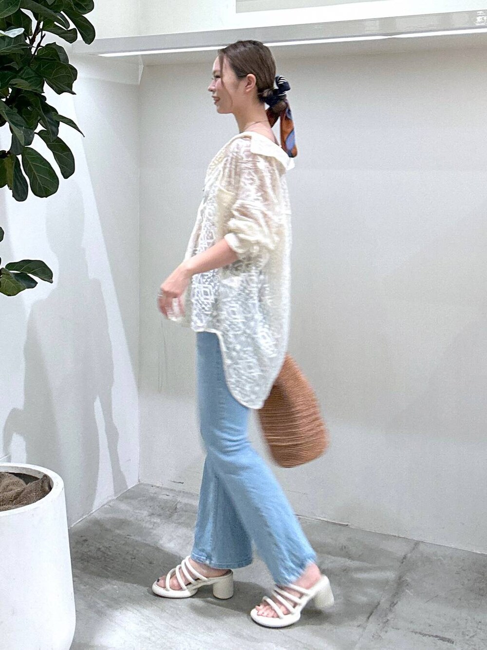 ブルー系のデニムパンツ、ピンク系のハンドバッグ、ホワイト系のシャツ/ブラウスを着用したレディースの春コーディネートの3枚目の写真