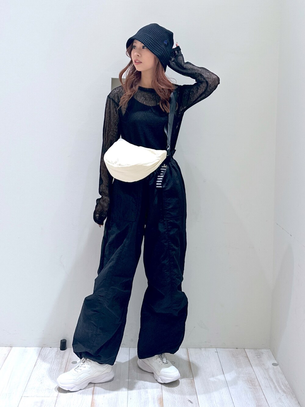 ブラック系のTシャツ/カットソー、ベージュ系のショルダーバッグ、ホワイト系のスニーカーを着用したレディースの春コーディネートの2枚目の写真