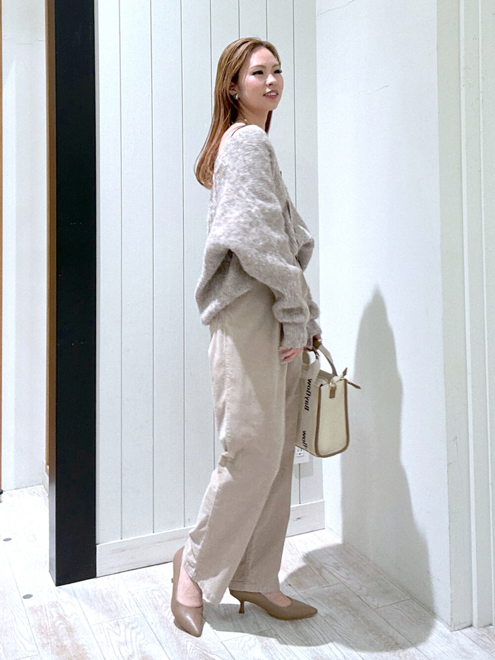 ベージュ系のその他パンツ、ブラウン系のカーディガン/ボレロ、ベージュ系のトートバッグを着用したレディースの冬コーディネートの3枚目の写真