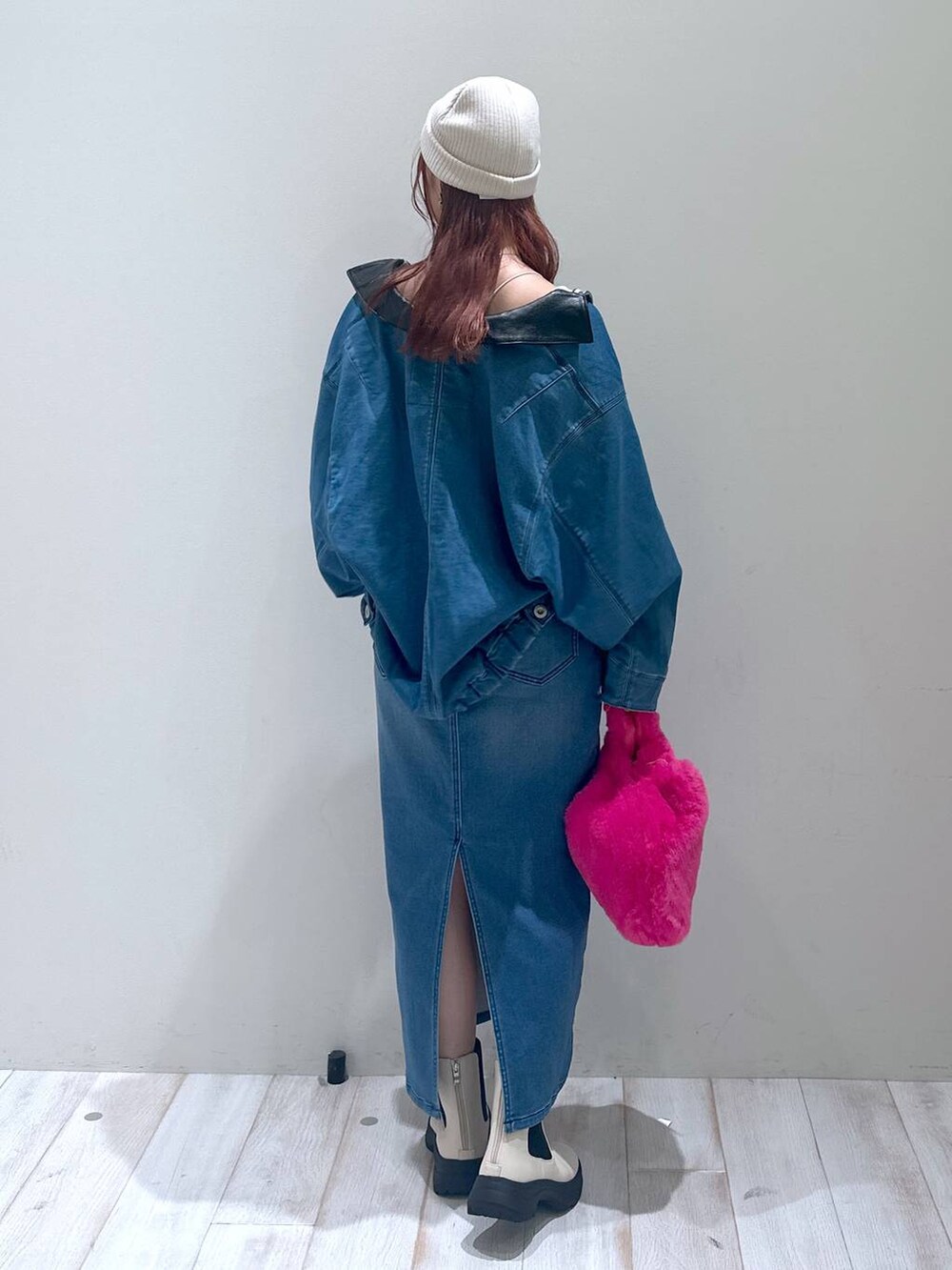 ブルー系のデニムスカート、ブルー系のブルゾン、ピンク系のハンドバッグを着用したレディースの秋コーディネートの4枚目の写真