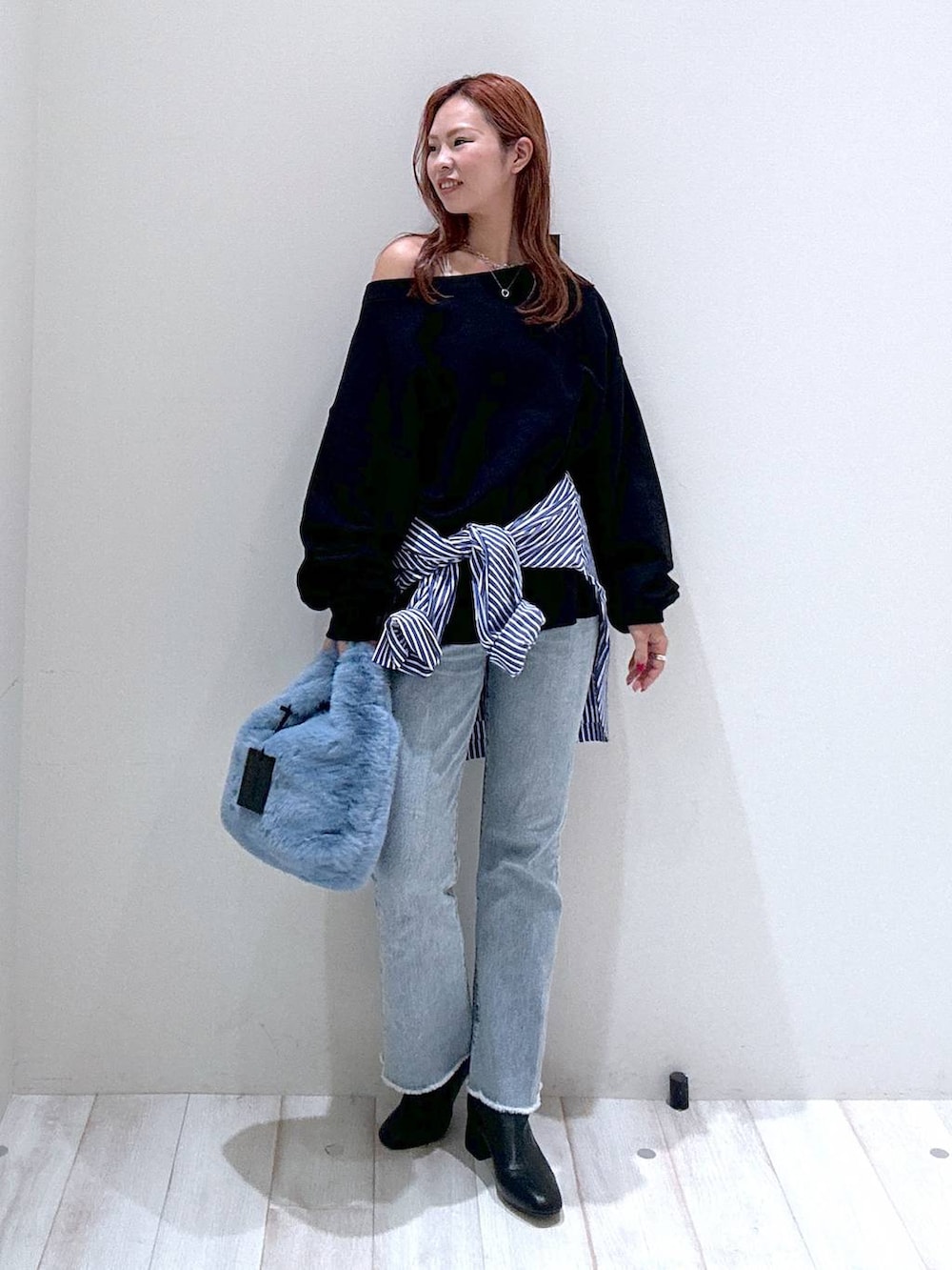 ブルー系のデニムパンツ、ブラック系のスウェット、ブルー系のシャツ/ブラウスを着用したレディースの秋コーディネートの2枚目の写真