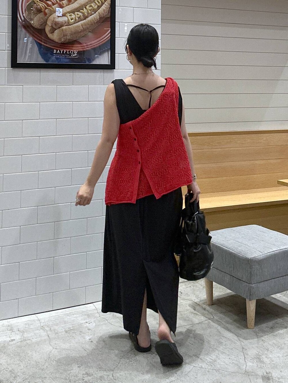 ブラック系のワンピース、ブラック系のトートバッグ、レッド系のカーディガン/ボレロを着用したレディースの夏コーディネートの3枚目の写真