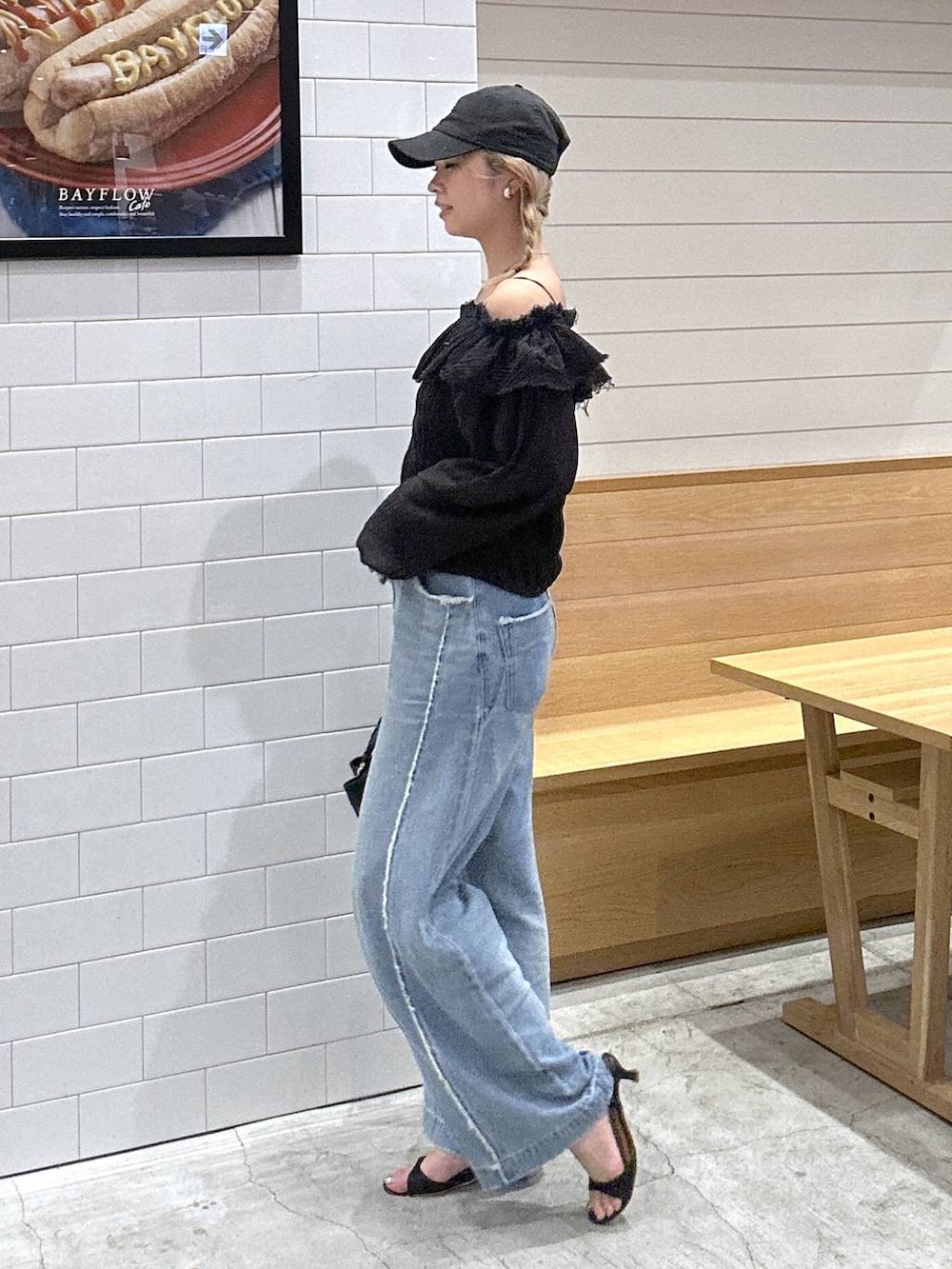 ブルー系のデニムパンツ、ブラック系のシャツ/ブラウス、ブラック系のショルダーバッグを着用したレディースの秋コーディネートの2枚目の写真