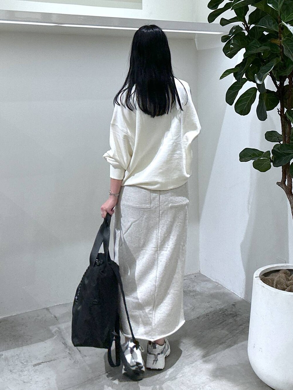 ホワイト系のスウェット、ホワイト系のスニーカー、ブラック系のバックパック/リュックを着用したレディースの冬コーディネートの3枚目の写真