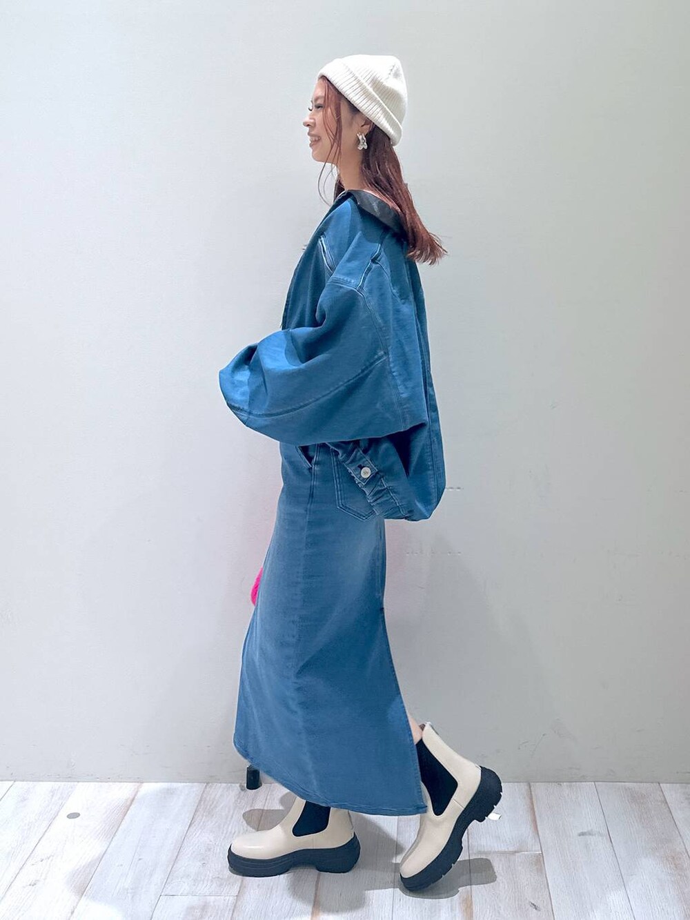 ブルー系のデニムスカート、ブルー系のブルゾン、ピンク系のハンドバッグを着用したレディースの秋コーディネートの3枚目の写真