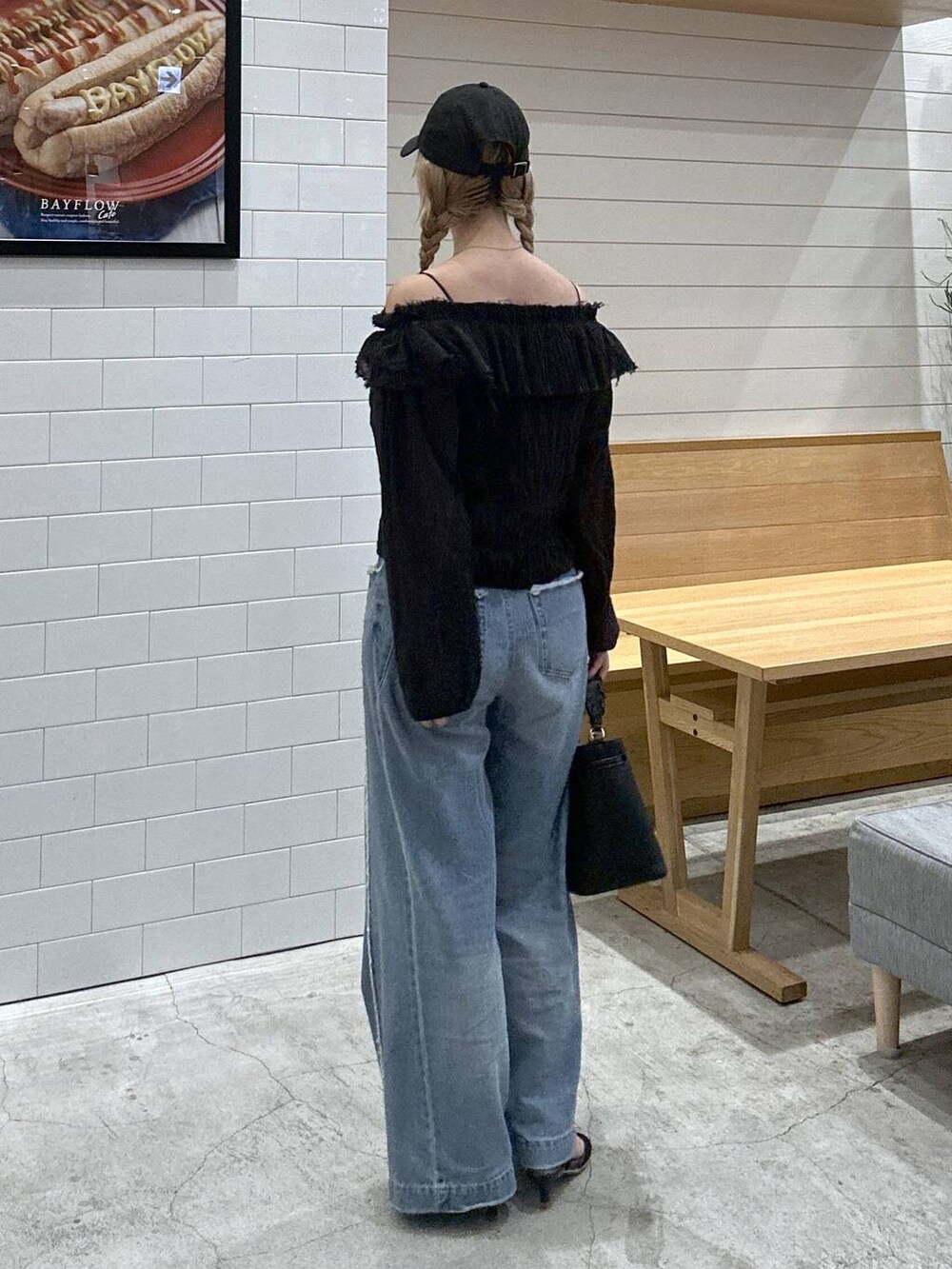 ブルー系のデニムパンツ、ブラック系のシャツ/ブラウス、ブラック系のショルダーバッグを着用したレディースの秋コーディネートの3枚目の写真