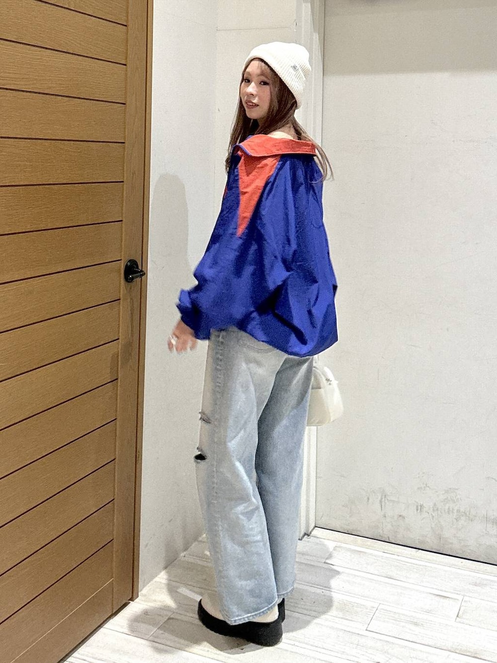 ブラック系のキャミソール、ベージュ系のブーツ、ブルー系のデニムパンツを着用したレディースの春コーディネートの2枚目の写真