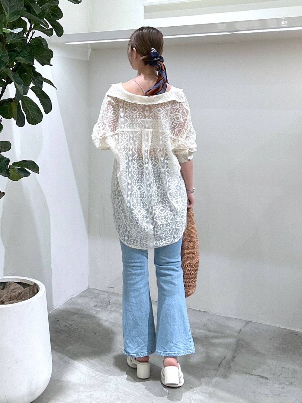 ブルー系のデニムパンツ、ピンク系のハンドバッグ、ホワイト系のシャツ/ブラウスを着用したレディースの春コーディネートの4枚目の写真