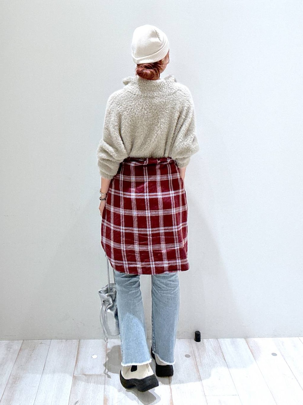 レッド系のシャツ/ブラウス、ブルー系のデニムパンツ、シルバー系のショルダーバッグを着用したレディースの秋コーディネートの3枚目の写真