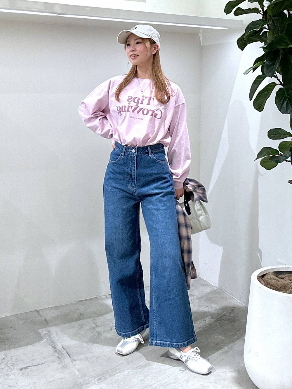 ピンク系のTシャツ/カットソー、ホワイト系のスニーカー、ブルー系のデニムパンツを着用したレディースの春コーディネートの2枚目の写真