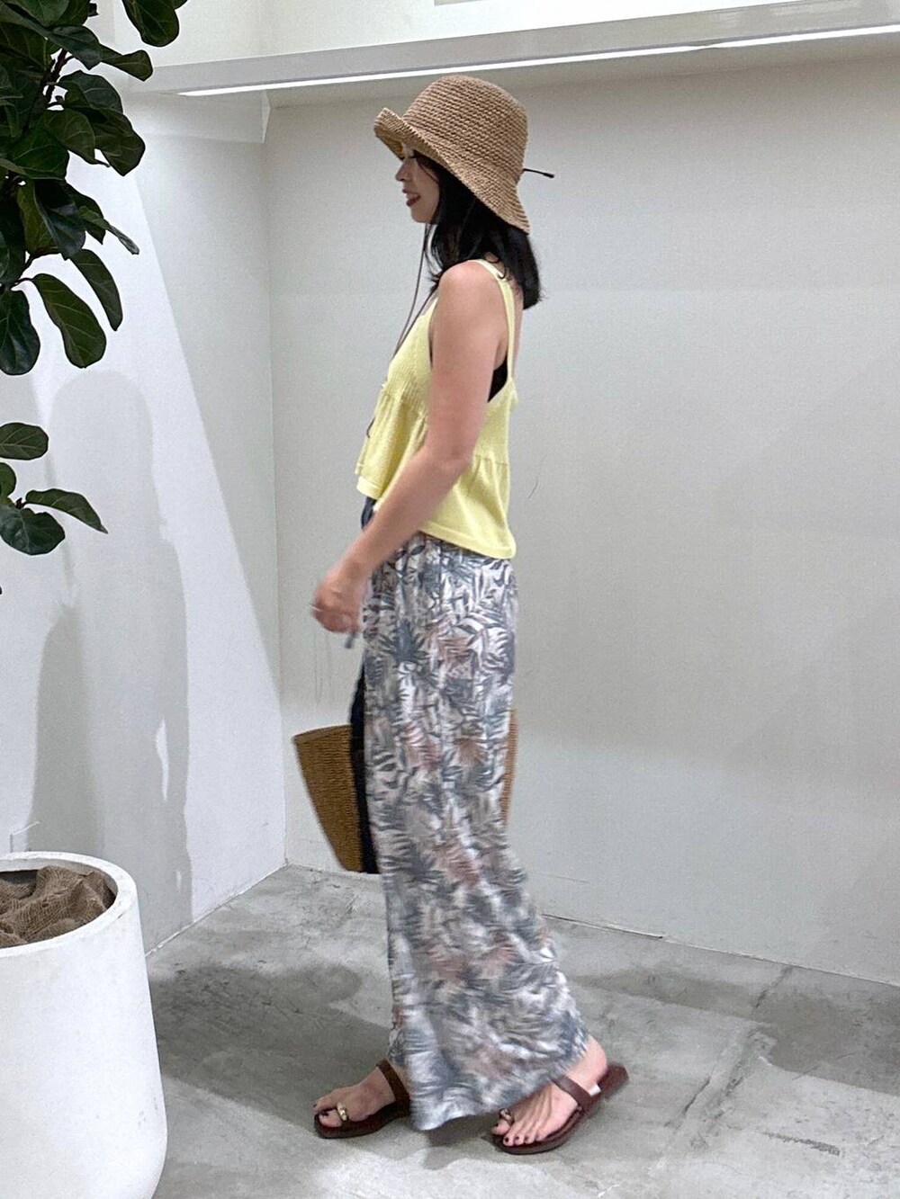 ブラウン系のトートバッグ、グリーン系のその他パンツ、ブラウン系のサンダルを着用したレディースの夏コーディネートの3枚目の写真