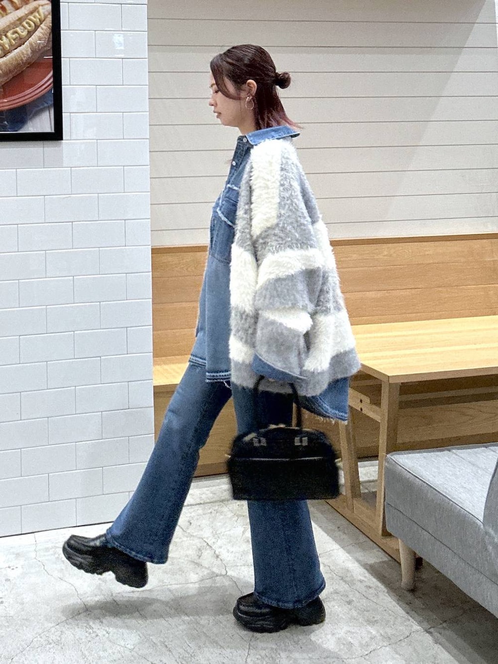 グレー系のカーディガン/ボレロ、ブルー系のシャツ/ブラウス、ブラック系のハンドバッグを着用したレディースの秋コーディネートの2枚目の写真