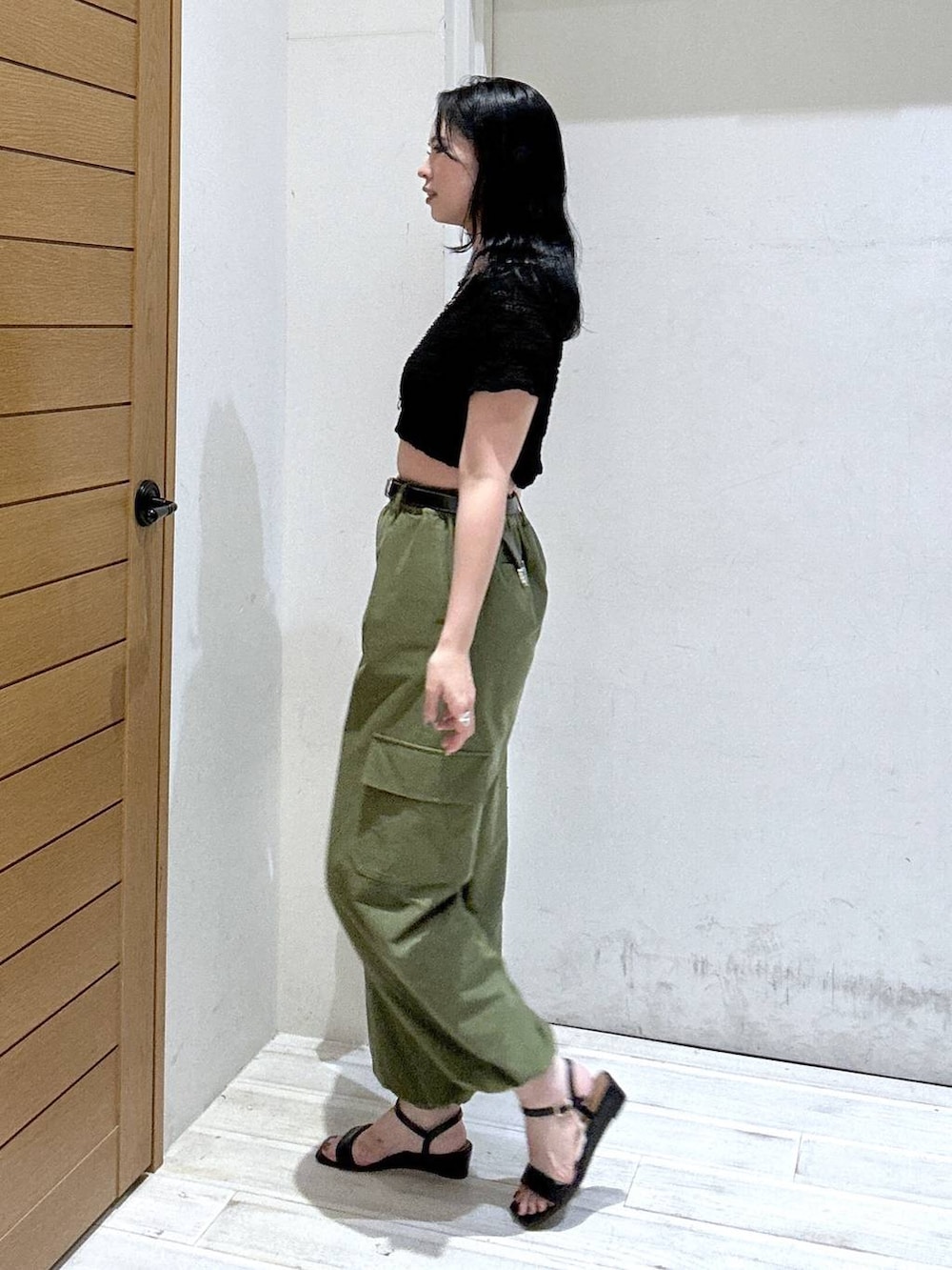 グリーン系のカーゴパンツ、ブラック系のサンダル、ブラック系のTシャツ/カットソーを着用したレディースの夏コーディネートの2枚目の写真
