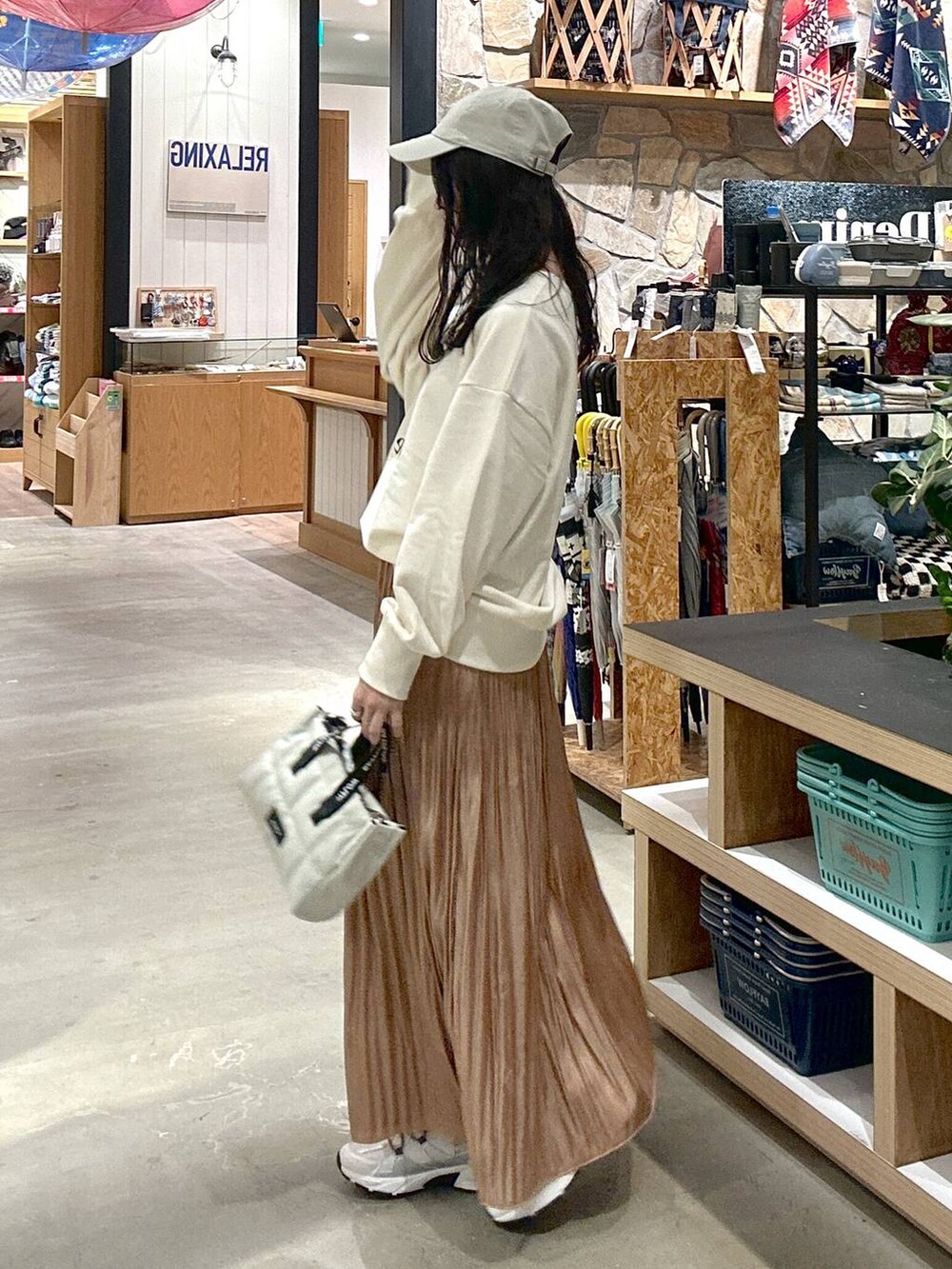 ホワイト系のスウェット、ベージュ系のショルダーバッグ、ブラック系のキャミソールを着用したレディースの冬コーディネートの3枚目の写真