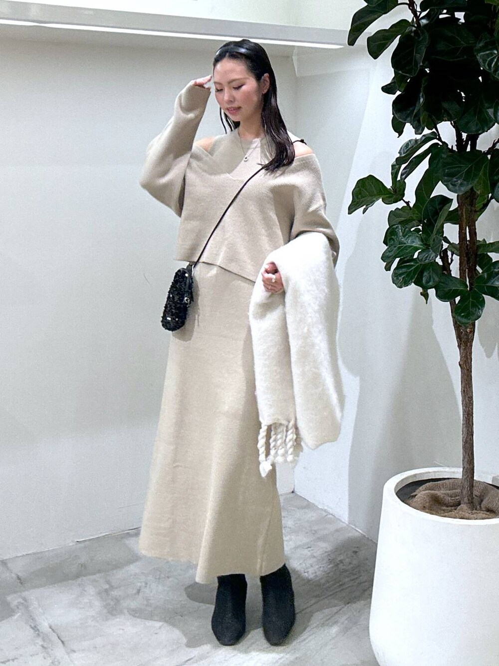 ブラック系のショルダーバッグ、ブラック系のブーツ、ブラウン系のワンピースを着用したレディースの冬コーディネートの2枚目の写真