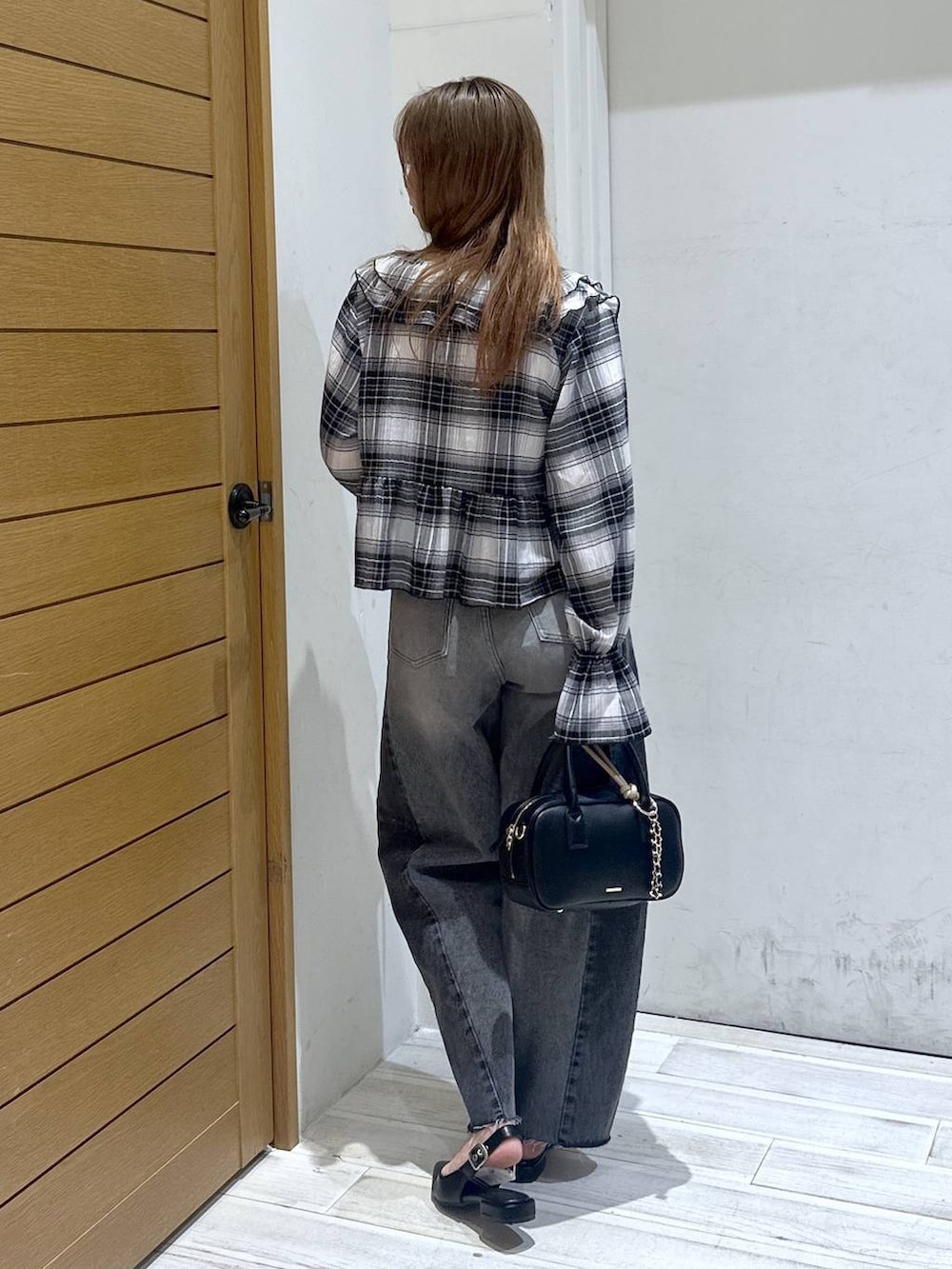 ブラック系のパンプス、ブラック系のデニムパンツ、ブラック系のハンドバッグを着用したレディースの春コーディネートの3枚目の写真