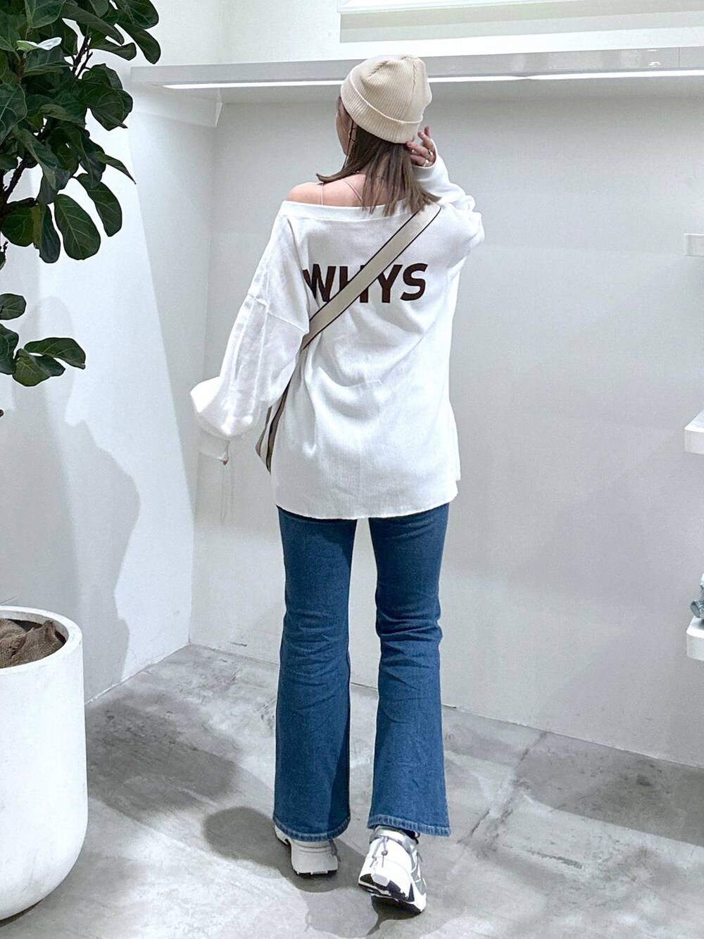 ホワイト系のスニーカー、ブルー系のデニムパンツ、ホワイト系のキャミソールを着用したレディースの春コーディネートの3枚目の写真