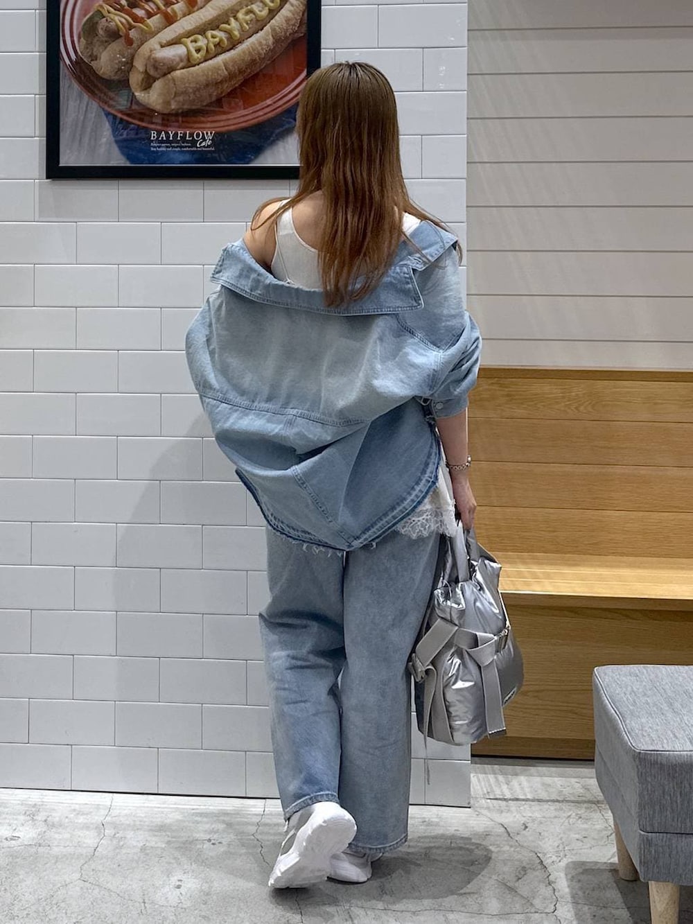 シルバー系のトートバッグ、ブルー系のデニムパンツ、ブルー系のデニムジャケットを着用したレディースの春コーディネートの3枚目の写真