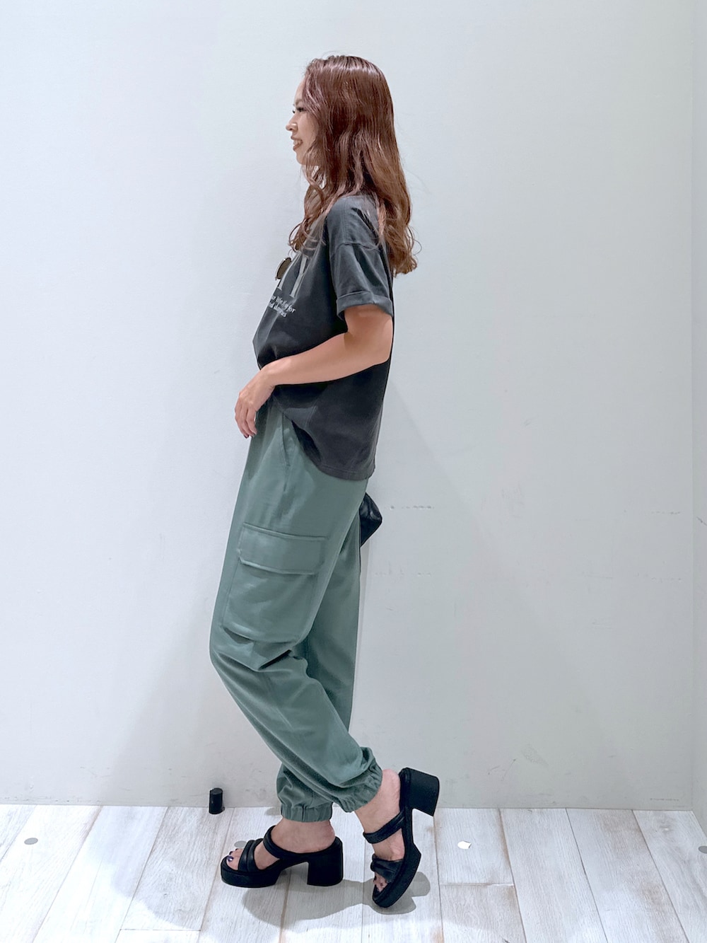 グリーン系のカーゴパンツ、ブラック系のショルダーバッグ、ブラック系のサンダルを着用したレディースの夏コーディネートの2枚目の写真