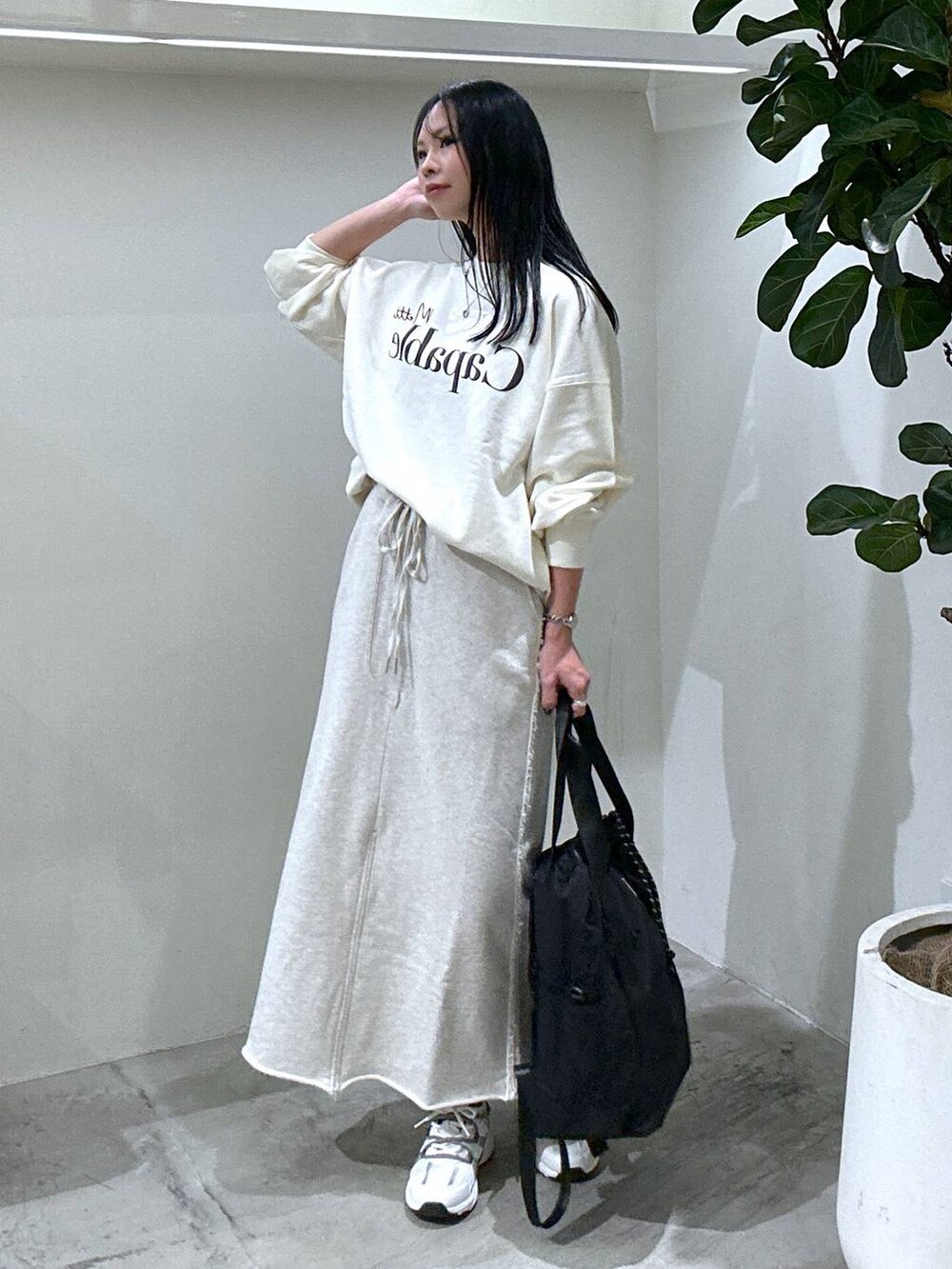 ホワイト系のスウェット、ホワイト系のスニーカー、ブラック系のバックパック/リュックを着用したレディースの冬コーディネートの2枚目の写真