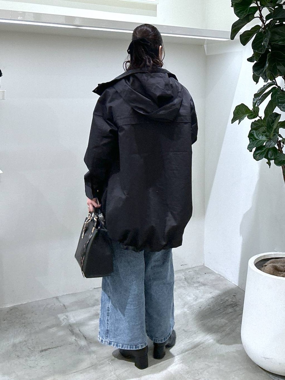 ブラック系のブーツ、ブラック系のハンドバッグ、ブラック系のマウンテンパーカーを着用したレディースの冬コーディネートの3枚目の写真