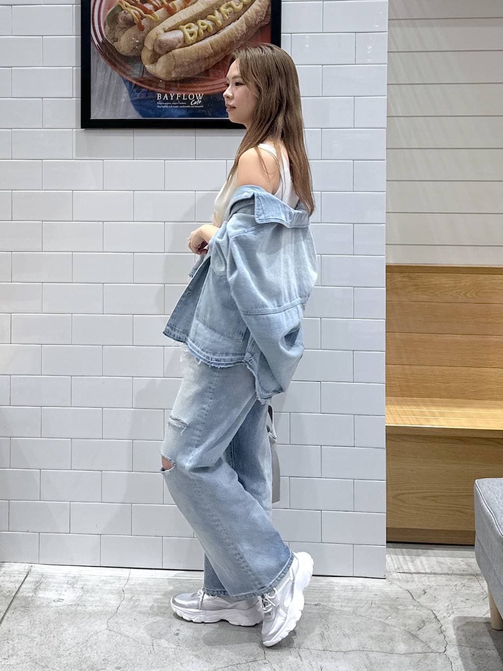 シルバー系のトートバッグ、ブルー系のデニムパンツ、ブルー系のデニムジャケットを着用したレディースの春コーディネートの2枚目の写真