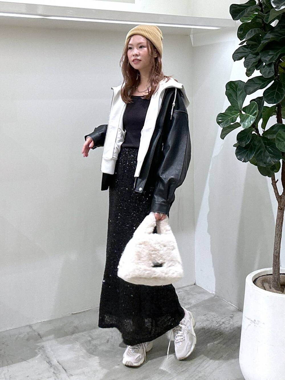 グレー系のスニーカー、ブラック系のその他アウター、グレー系のパーカーを着用したレディースの秋コーディネートの2枚目の写真