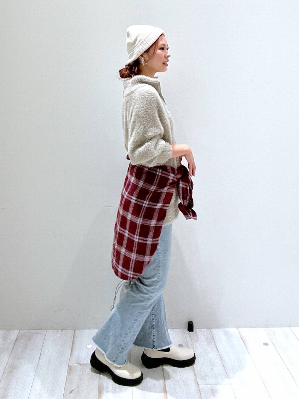 レッド系のシャツ/ブラウス、ブルー系のデニムパンツ、シルバー系のショルダーバッグを着用したレディースの秋コーディネートの2枚目の写真